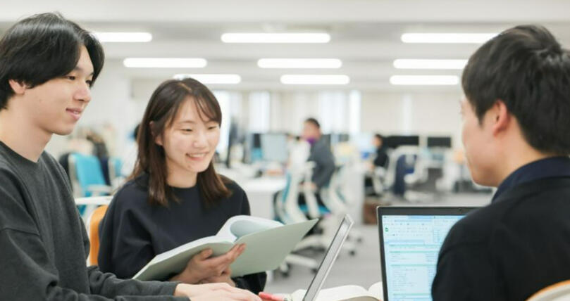 Two Japanese accountants, one male and one female having a consultation with a male customer. The male is holding accounting documents and the female is smiling